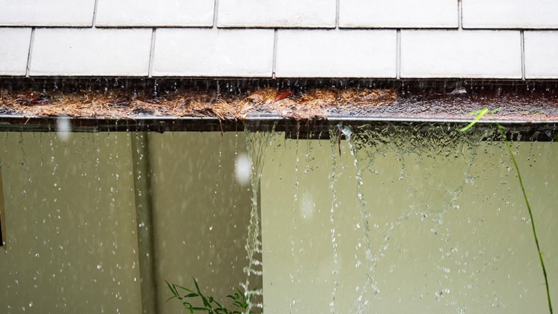 Water overflowing from gutters causing water damage to a home